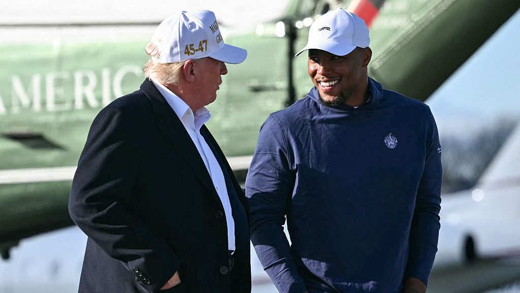 TOPSHOT - US President Donald Trump (L) walks with Philadelphia Eagles running back Saquon Barkley before boarding Air Force One Morristown Municipal Airport in Morristown, New Jersey, on April 27, 2025. Trump is returning to Washington, DC, from his residence in Bedminster, New Jersey, after traveling to Rome for the funeral of Pope Francis. (Photo by Mandel NGAN / AFP) (Photo by MANDEL NGAN/AFP via Getty Images)