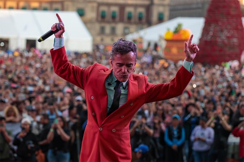Café Tacvba frontman Rubén Albarrán on stage in a red suit jacket